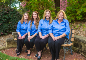 The Culberson Orthodontics staff sitting on a bench