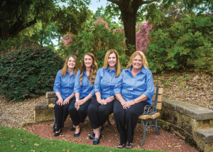The Culberson Orthodontics staff sitting on a bench