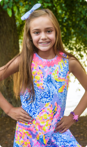 Early orthodontic treatment patient with metal braces and a bow in her hair