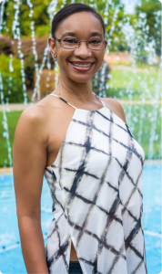 Woman wearing braces for adults and standing next to a fountain