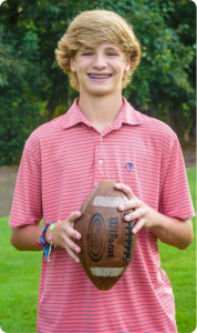 Teen with metal braces holding football